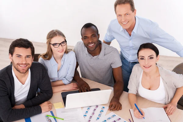 Group of business people in casual wear sitting together at the table — Stock Photo, Image