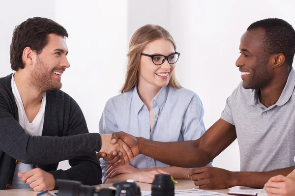 Twee business mensen handshaking terwijl vrouw zitten tussen hen — Stockfoto