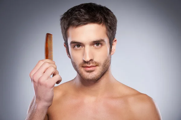 Man holding a comb — Stock Photo, Image