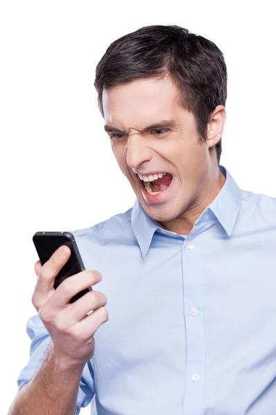 Wütender junger Mann brüllt sein Handy an — Stockfoto