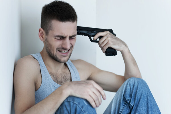 Man holding gun near his head