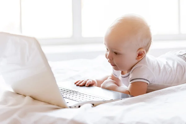 Baby holding hands on laptop keyboard — Stock Photo, Image