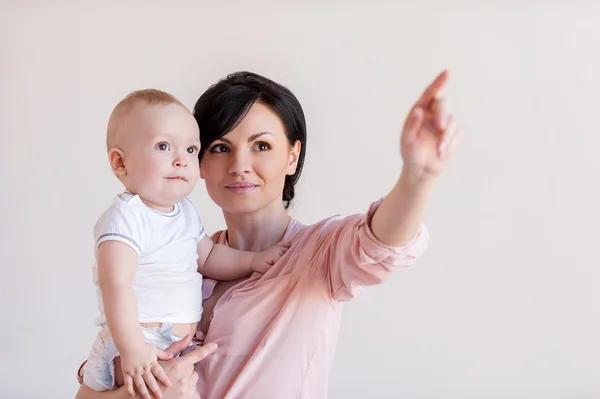 Mother holding baby and pointing away — Stock Photo, Image