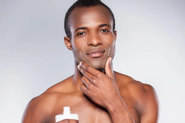 Hombre africano aplicando crema en la cara — Foto de Stock