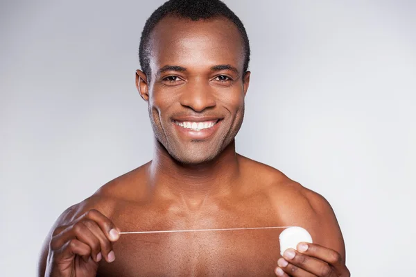 Hombre africano sosteniendo hilo dental —  Fotos de Stock