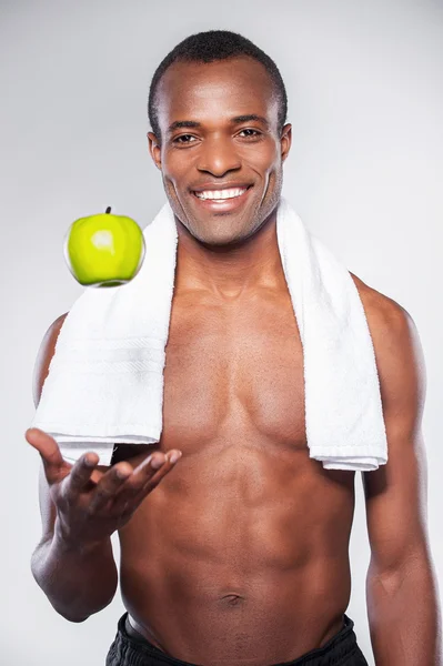 African man throwing up apple — Stock Photo, Image