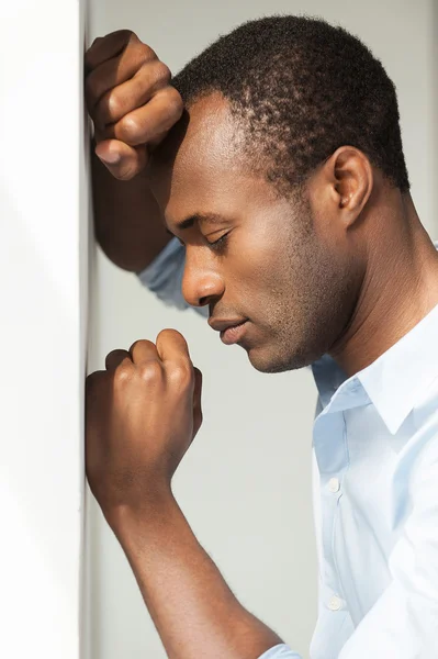 Uomo africano in camicia blu appoggiato al muro — Foto Stock