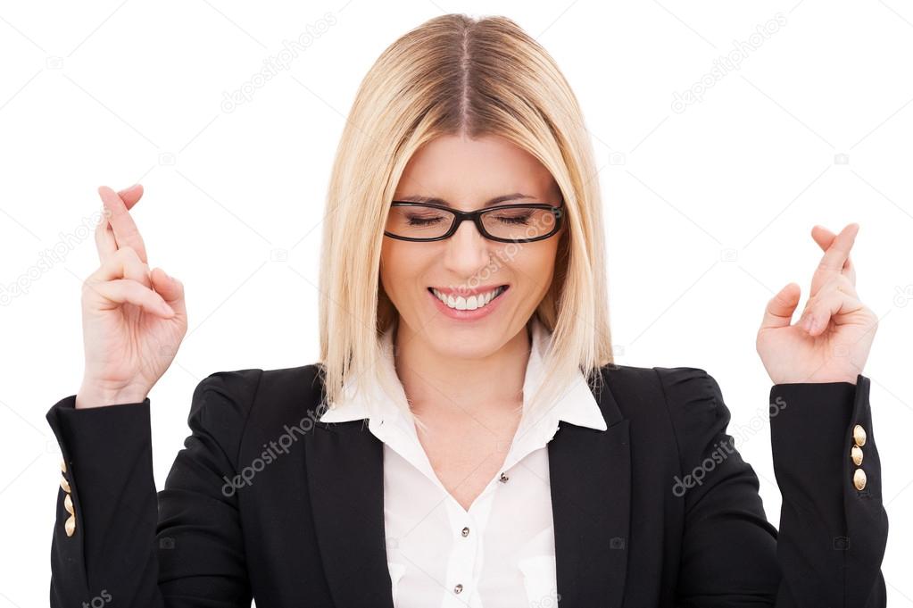 Businesswoman keeping eyes closed and fingers crossed