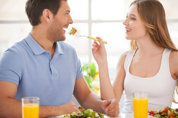 Woman feeding boyfriend with salad Stock Photo