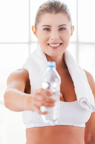 Mujer con ropa deportiva estirando una botella — Foto de Stock