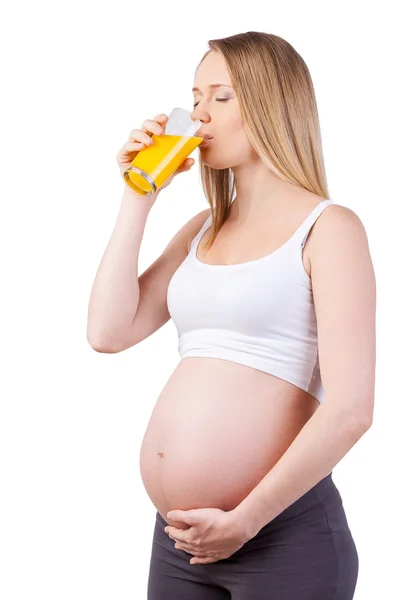 Pregnant woman drinking orange juice — Stock Photo, Image