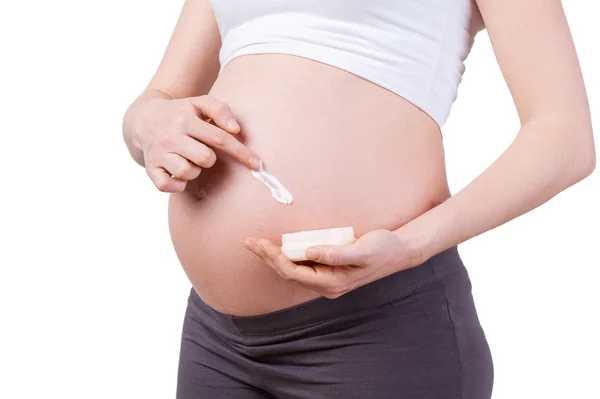 Hamile kadın nemlendirici uygulayarak — Stok fotoğraf