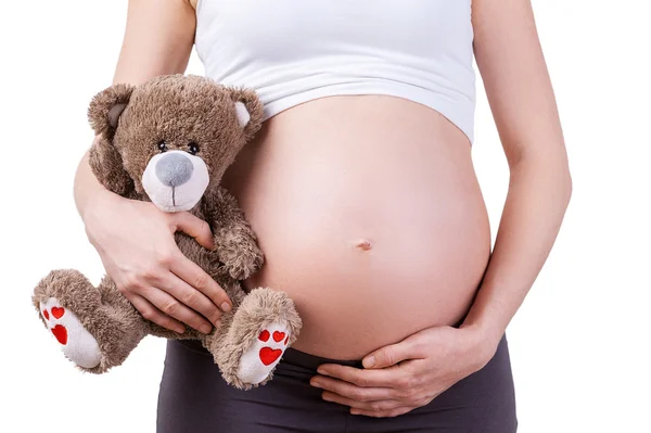 Zwangere vrouw met teddybeer. — Stockfoto