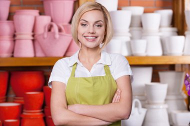 saksı ile raf karşı duran kadın