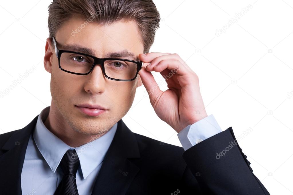 Man in formalwear adjusting glasses