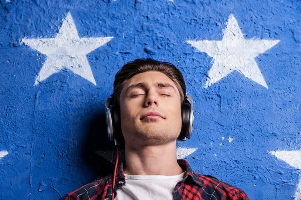 Hombre con auriculares manteniendo los ojos cerrados — Foto de Stock