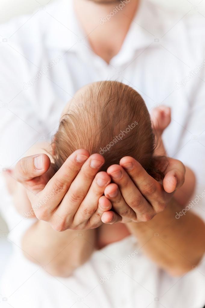 Baby in fathers hands.