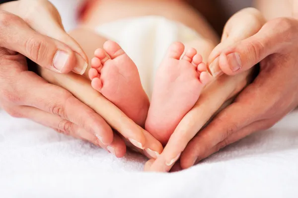 Pais segurando os pés do bebê — Fotografia de Stock