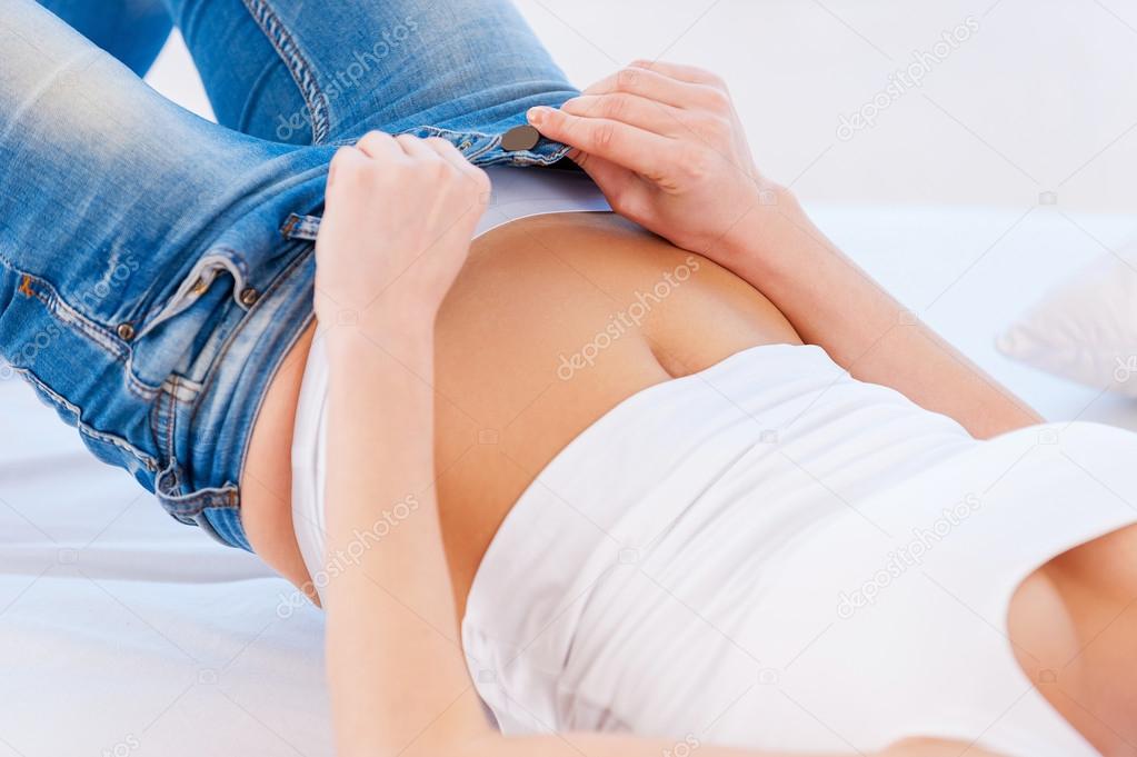Woman pulling on tight jeans