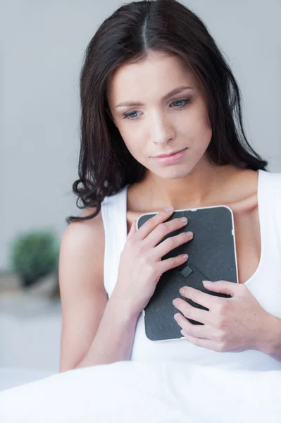 Woman holding a photo frame and crying — Stock Photo, Image