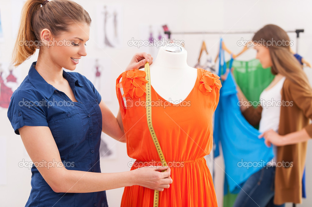 Designer measuring dress.