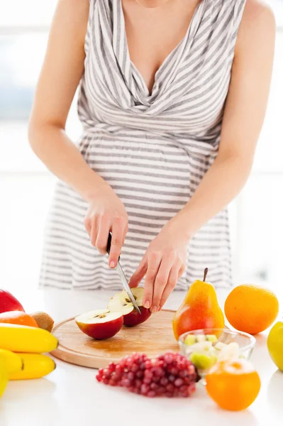 Mulher grávida fazendo uma salada de frutas — Fotografia de Stock
