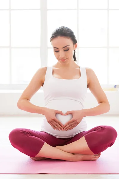 Pregnant woman sitting in lotus position — Stock Photo, Image