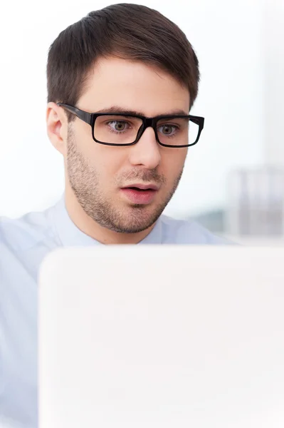 Überraschter Mann schaut auf Laptop — Stockfoto