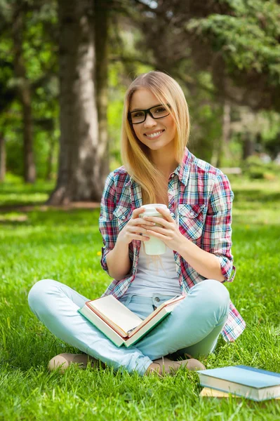 Student sedí v parku s knihami — Stock fotografie