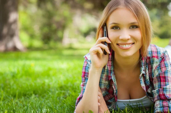 Vrouw praten over telefoon in park — Stockfoto