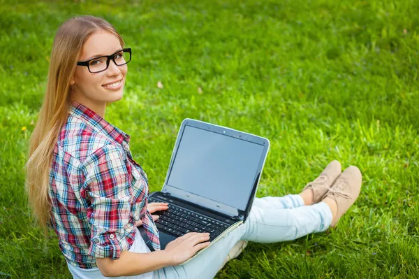 Student werkt aan laptop in park — Stockfoto