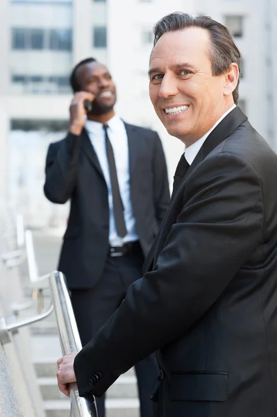 Senior man in formal wear moving up by stairs — Stock Photo, Image