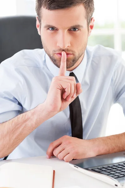 Мужчина в формальной одежде держит палец на губах — стоковое фото