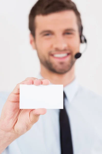 Man in headset stretching outbusiness card Stock Photo