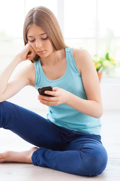 Dospívající dívka drží mobil v depresi — Stock fotografie