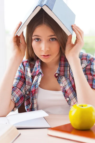 Adolescente portant livre sur la tête — Photo