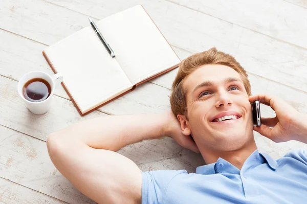 Man praten over telefoon en liggend op de vloer — Stockfoto