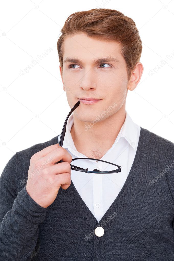 Thoughtful young man holding glasses