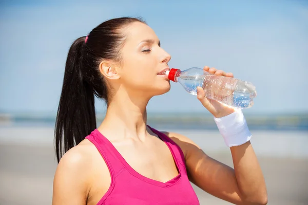 Woman drinking water after jog. — Stock Photo, Image