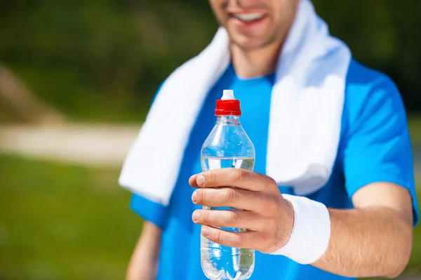 Man stretching out a bottle with water — Stock Photo, Image