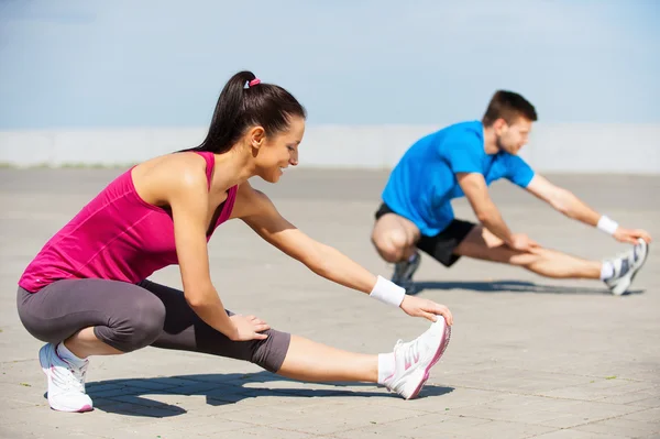Woman and man doing stretching exercises — Stock Photo, Image