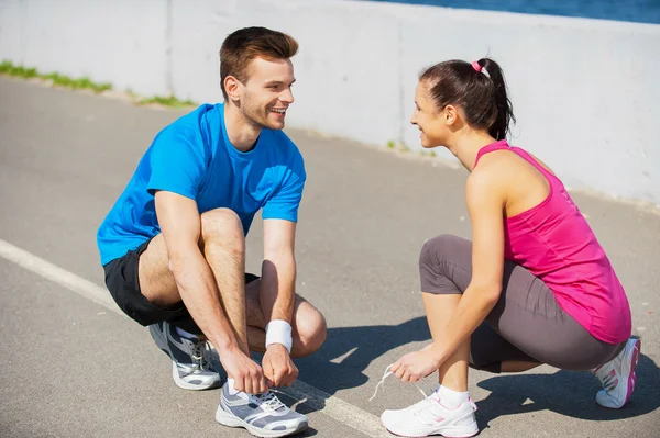 Man and woman tying shoelaces — Stock Photo, Image