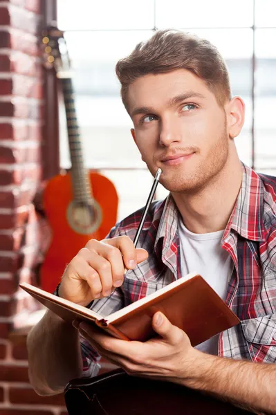 Hombre escribiendo algo en bloc de notas — Foto de Stock