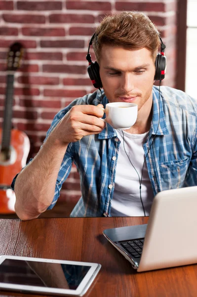 Homem em fones de ouvido trabalhando no laptop — Fotografia de Stock