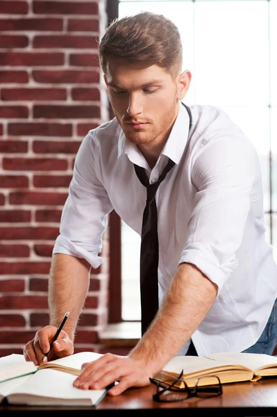 Hombre con camisa y corbata escribiendo en bloc de notas a — Foto de Stock