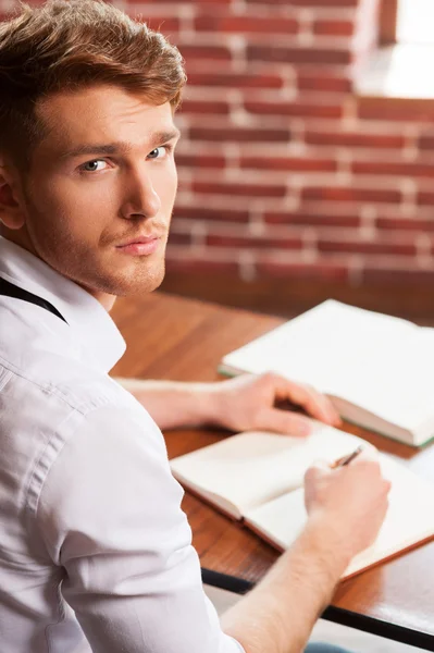 Man in overhemd en stropdas schrijven in Opmerking pad — Stockfoto