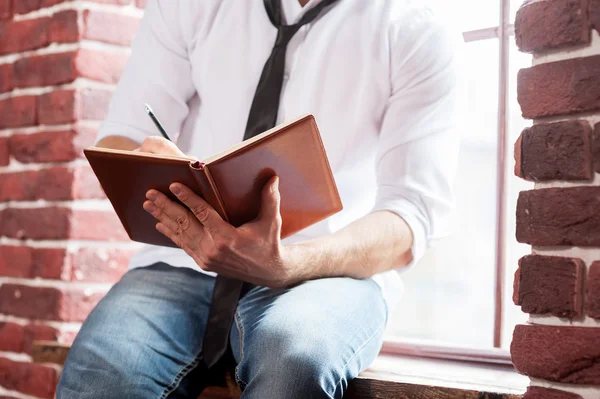 Homem escrevendo em bloco de notas — Fotografia de Stock