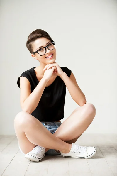 Kort hår kvinna sitter på golvet — Stockfoto