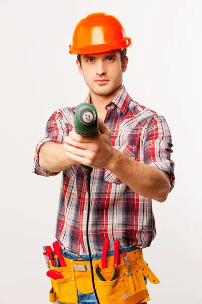 Handyman in hardhat che si estende trapano — Foto Stock