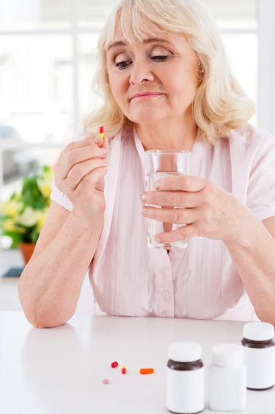 Depressed senior woman holding pill — Stock Photo, Image